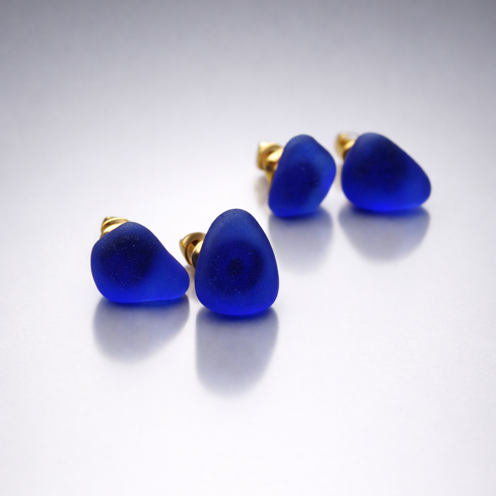 cobalt blue sea glass stud earrings with gold backing coastal luxury jewelry earrings with gold posts on a light gray background