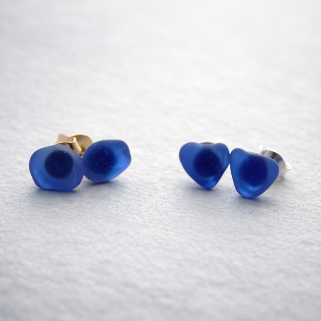 Pair of blue heart-shaped earrings on a light gray background