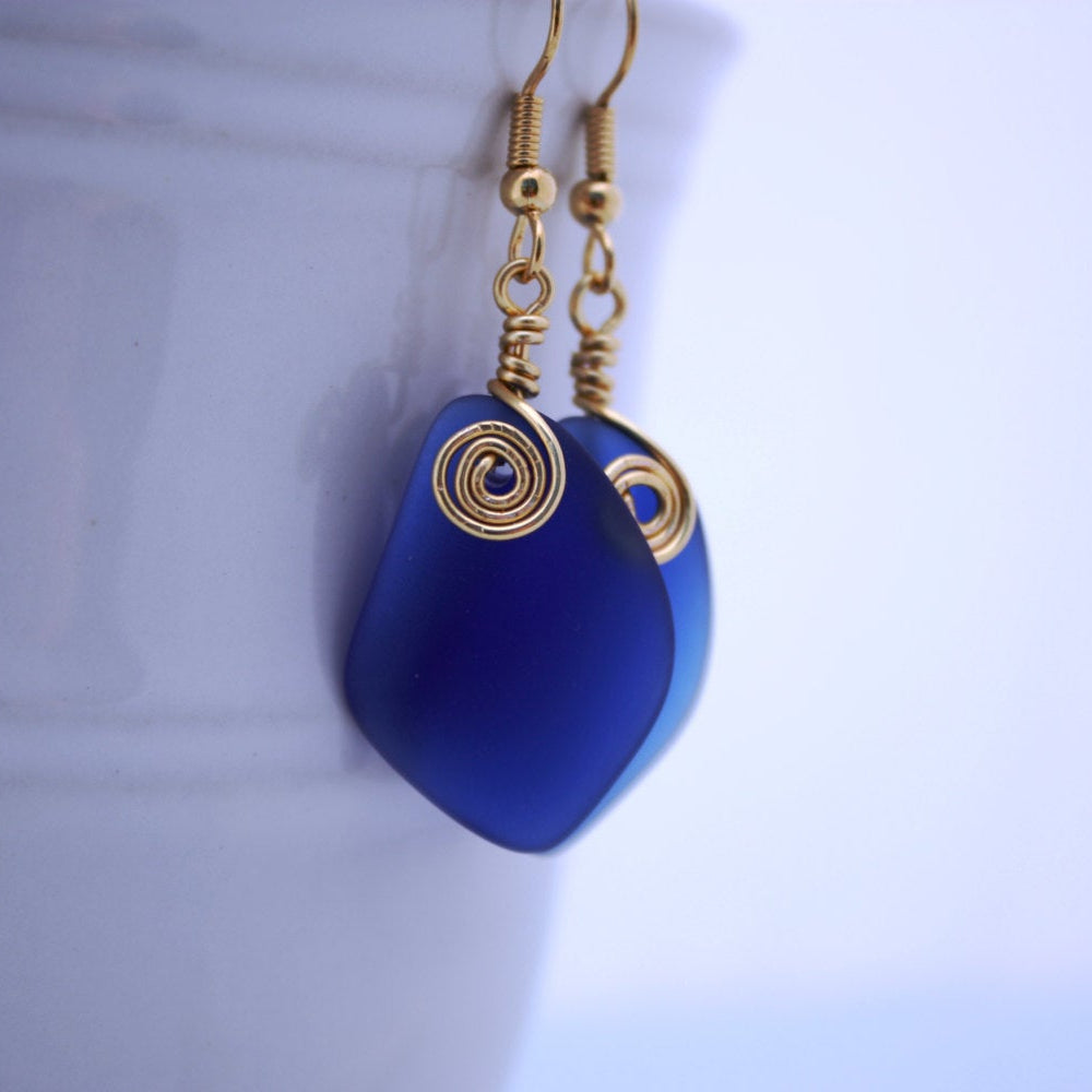 Handmade blue sea glass earrings with gold swirl accent, elegant beach jewelry